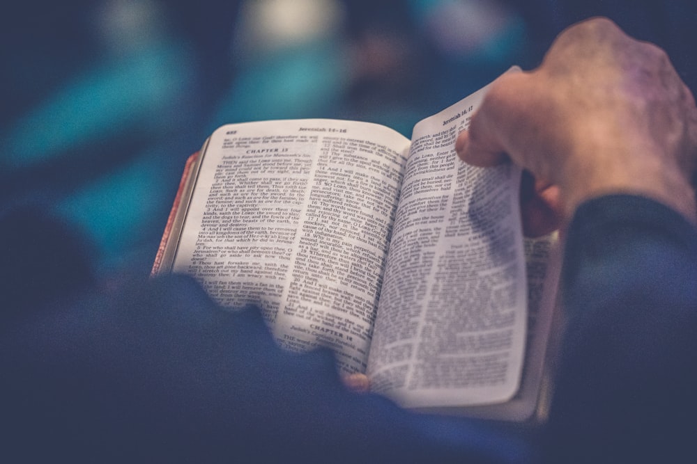 Hands reading open Bible